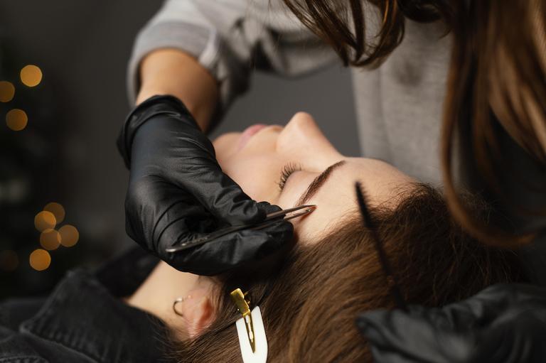 front-view-female-specialist-doing-eyebrow-treatment-woman-min (1).jpg